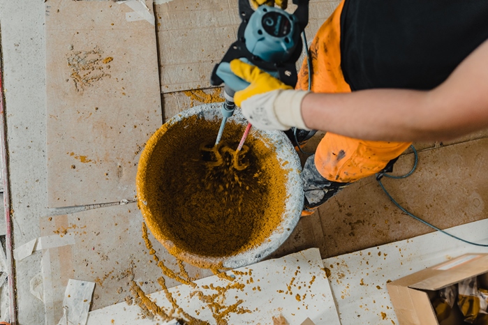pekerja mencampur mortar poliuretan berwarna dengan resin epoxy